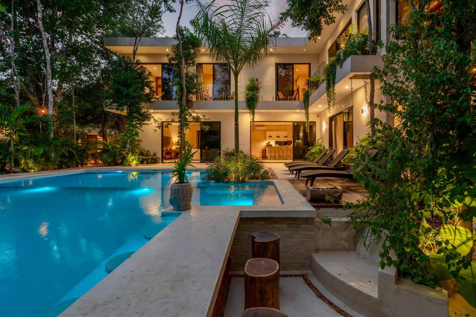 Luxury Tampa Bay home at dusk with warm architectural lighting and pool